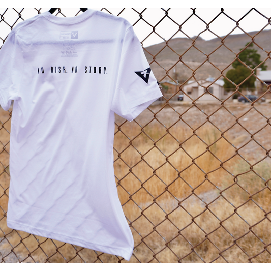 SOLID WHITE BLEND TEE WITH BLACK DESIGN "NO RISK. NO STORY." & "VISIONARIO" EMBLEM ON LEFT POCKET.